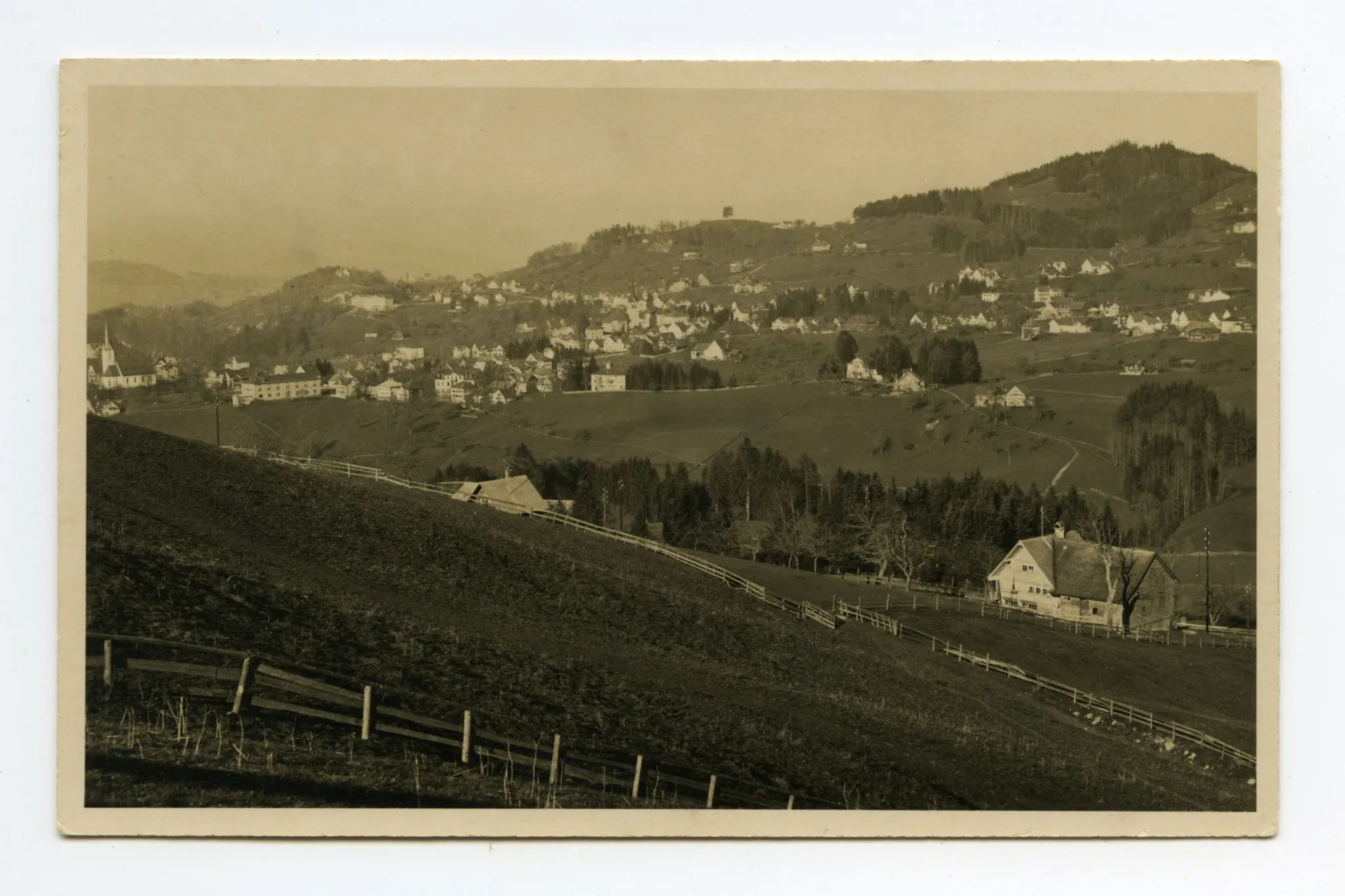 Aufnahme aus Richtung Schlatterlehn/Buechen. Beide Dorfkirchen, Zeughaus, Friedhof, Ebni, Bahnhof (halb verdeckt), Gremm/Lortanne mit Krankenhaus. Blick zu Fernblick, Schwendibüel, resp. Eggli