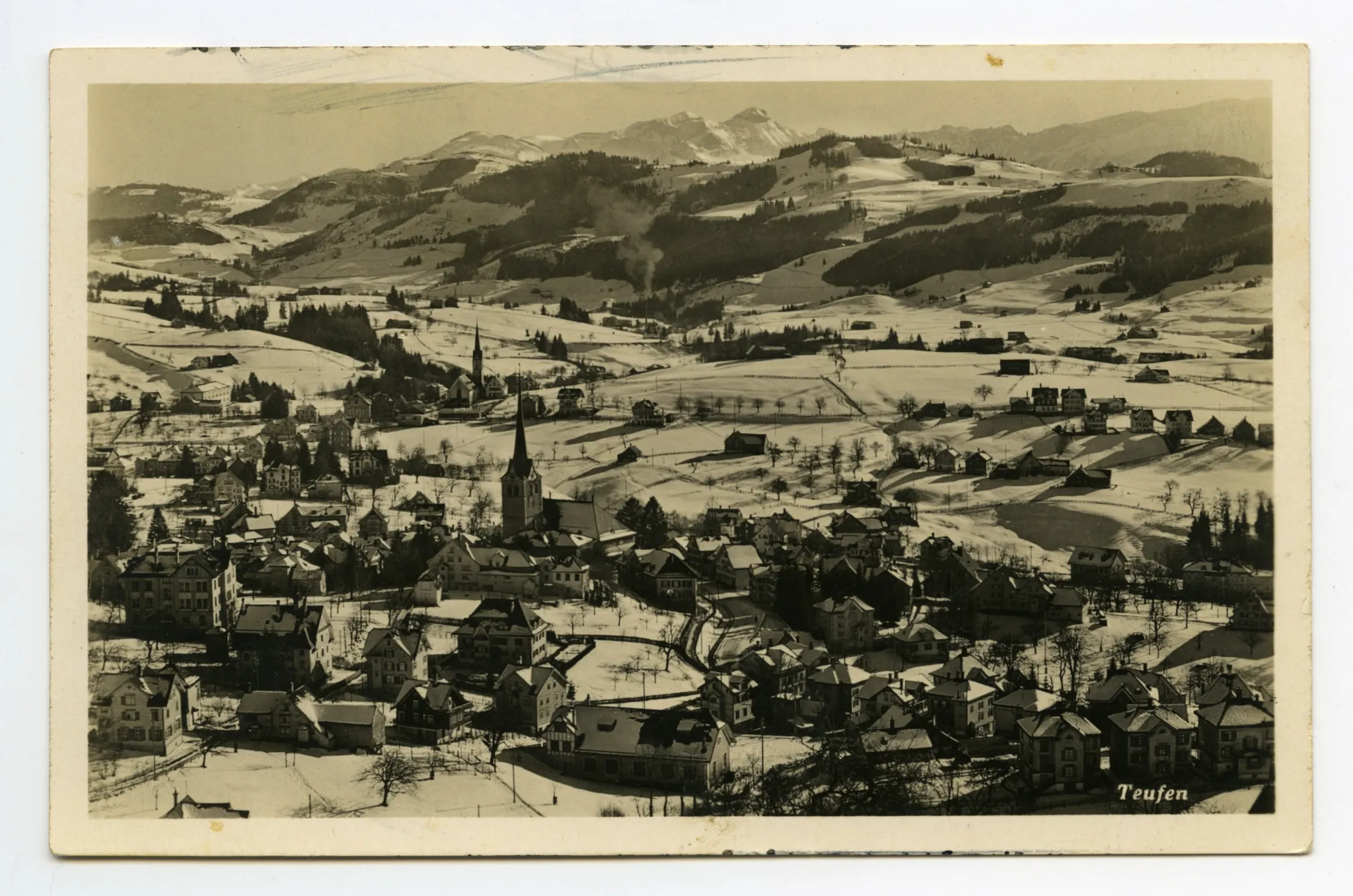 vorne alte Turnhalle, beide Dorfkirchen. Blick zu Steigbach (Rauch aus Hochkamin), Kamor/Hohem Kasten