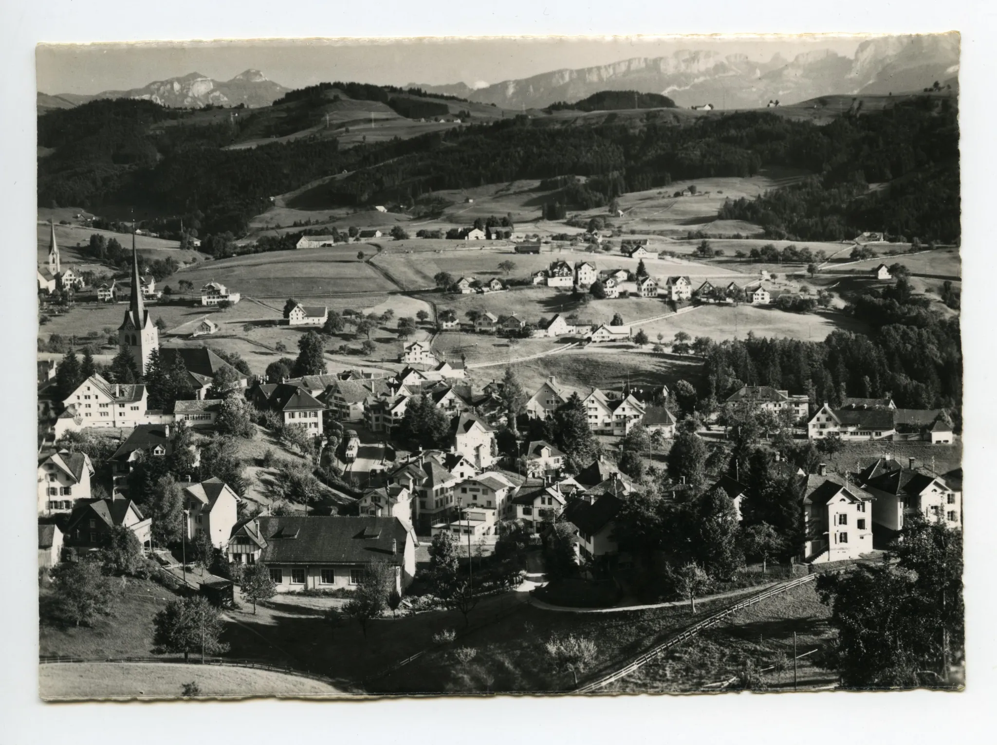 beide Dorfkirchen (alte Kath. Kirche z.T.). Vorne alte Turnhalle, SGA-Komposition Ausfahrt Dorfplatz. Blick zu Steigbach (Hochkamin), Kamor/Hohem Kasten, östl. Alpstein