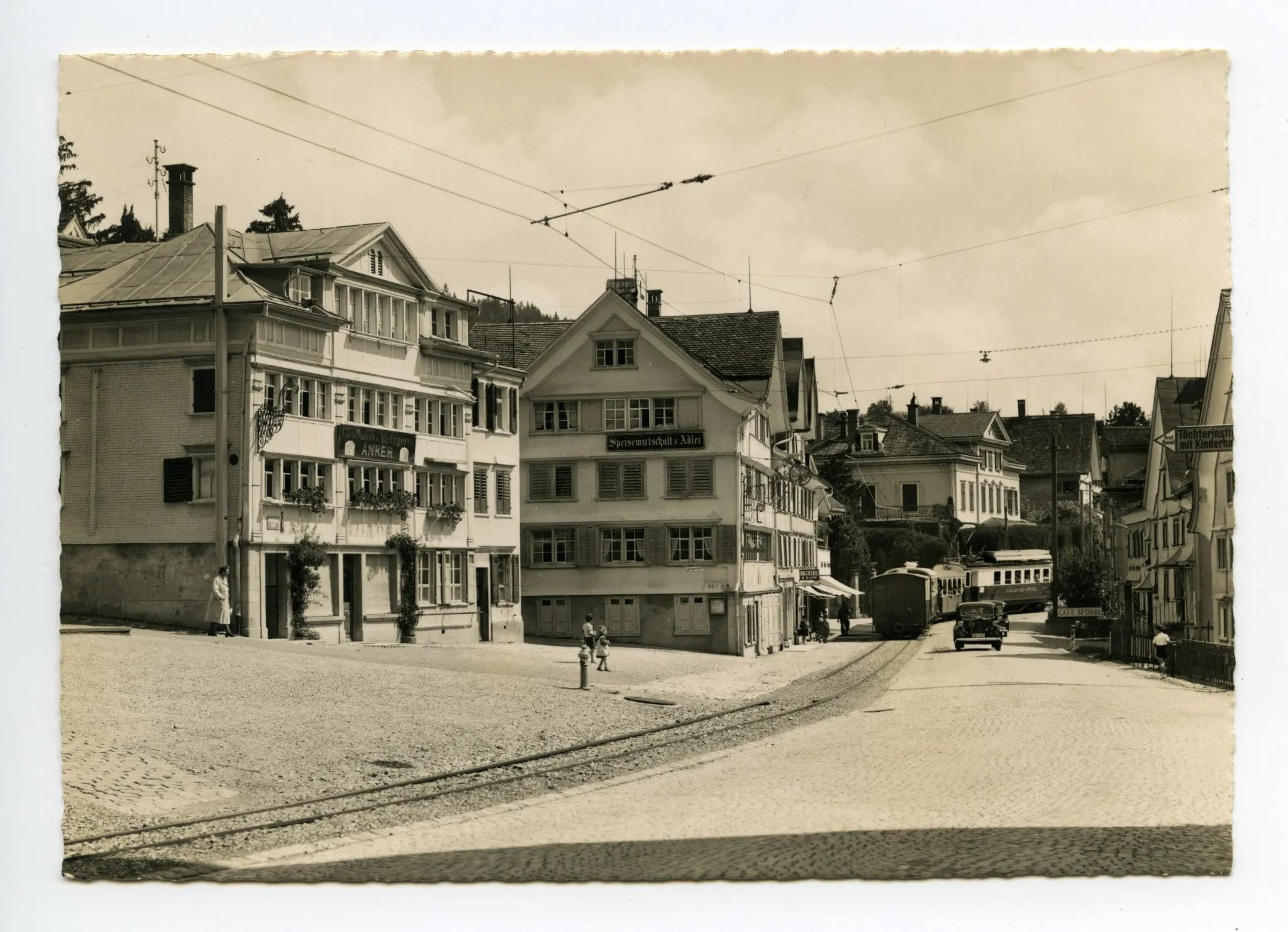 mit „Anker“ und „Adler“, Blick zur Dorfstrasse-Ost und Villa Roth. Elektro-Komposition der SGA, Fahrt Richtung Gais, Autos. Vor Kornhändlerhaus (z.T. sichtbar) Wegweiser: Prof. Buser: „Töchterinstitut mit Kinderhaus“