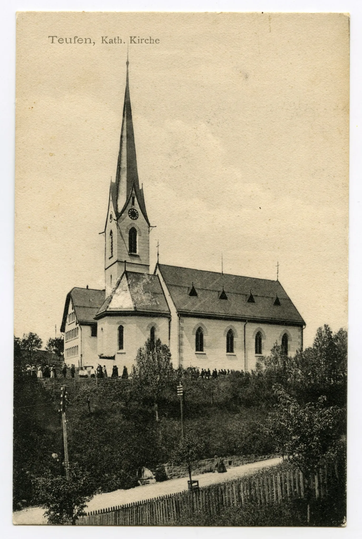 Mit Prozession (Beerdigung?) entlang der Kirche. Vorne: Hauptstrasse im Sammelbüel (vgl. Hc.06-01)