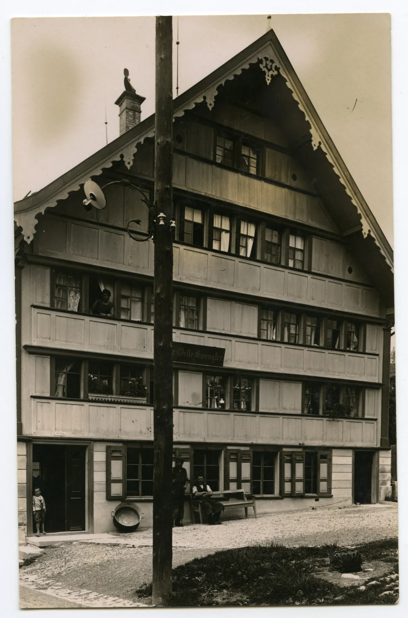 Ansicht mit Bewohner vor dem Haus und aus dem Fenster schauend