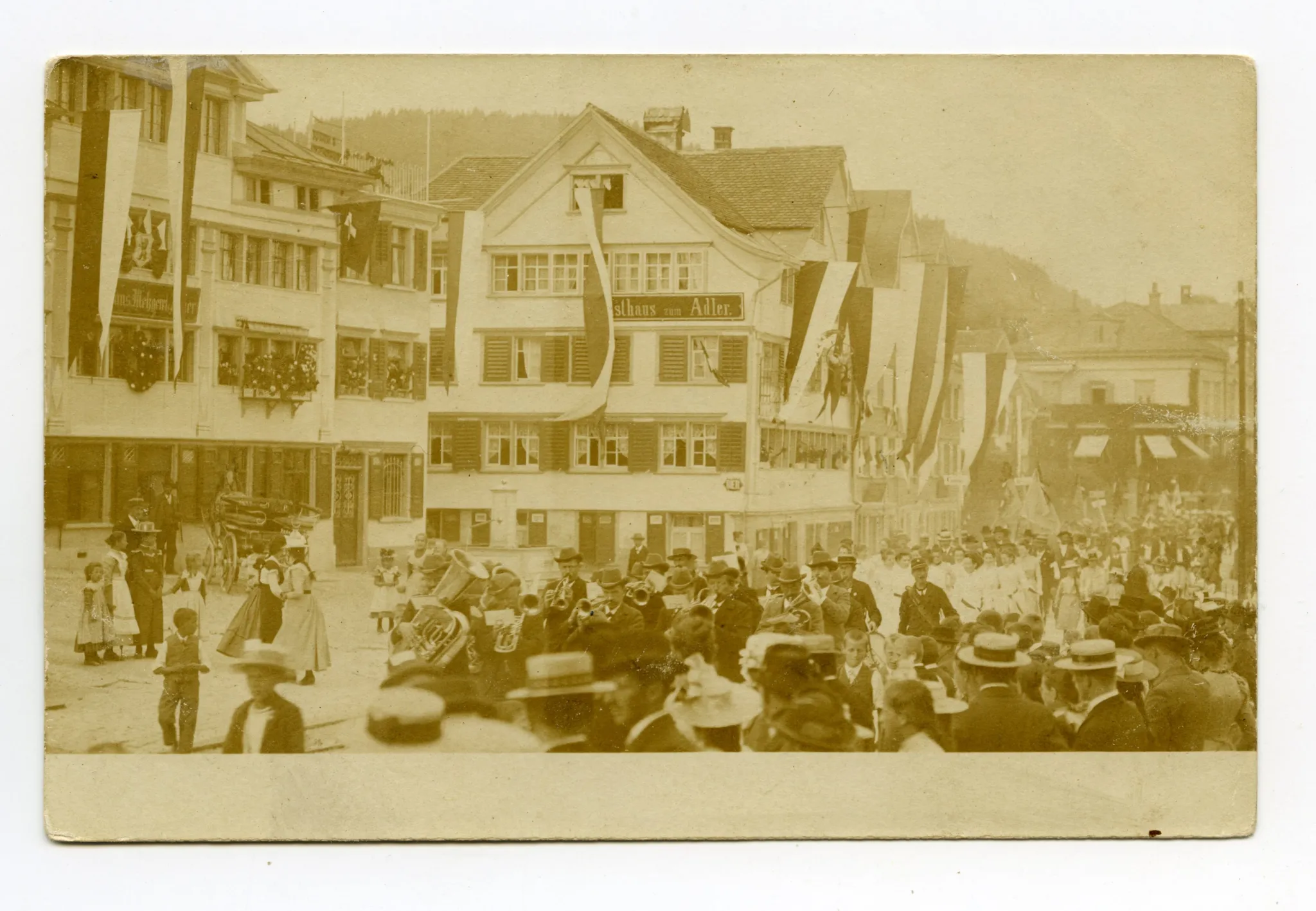 vor Häuserzeile mit Gasthaus Anker, Gasthaus zum Adler und Villa Roth im Hintergrund, Fahnenschmuck an Häusern