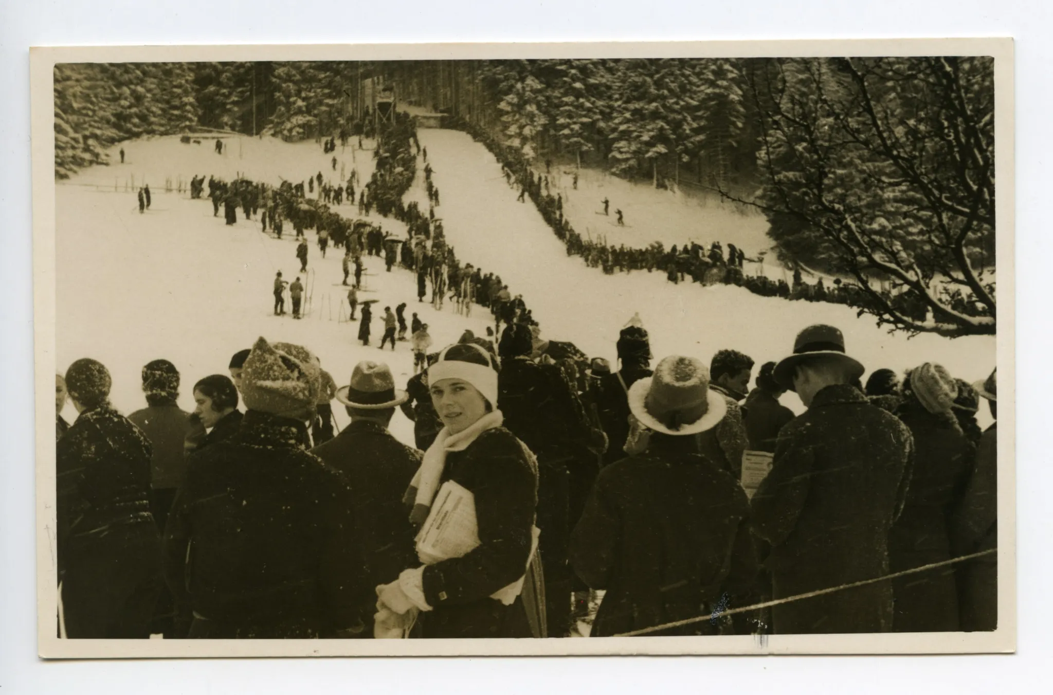 Winter, Skifahrer und Zuschauer säumen die Schanze