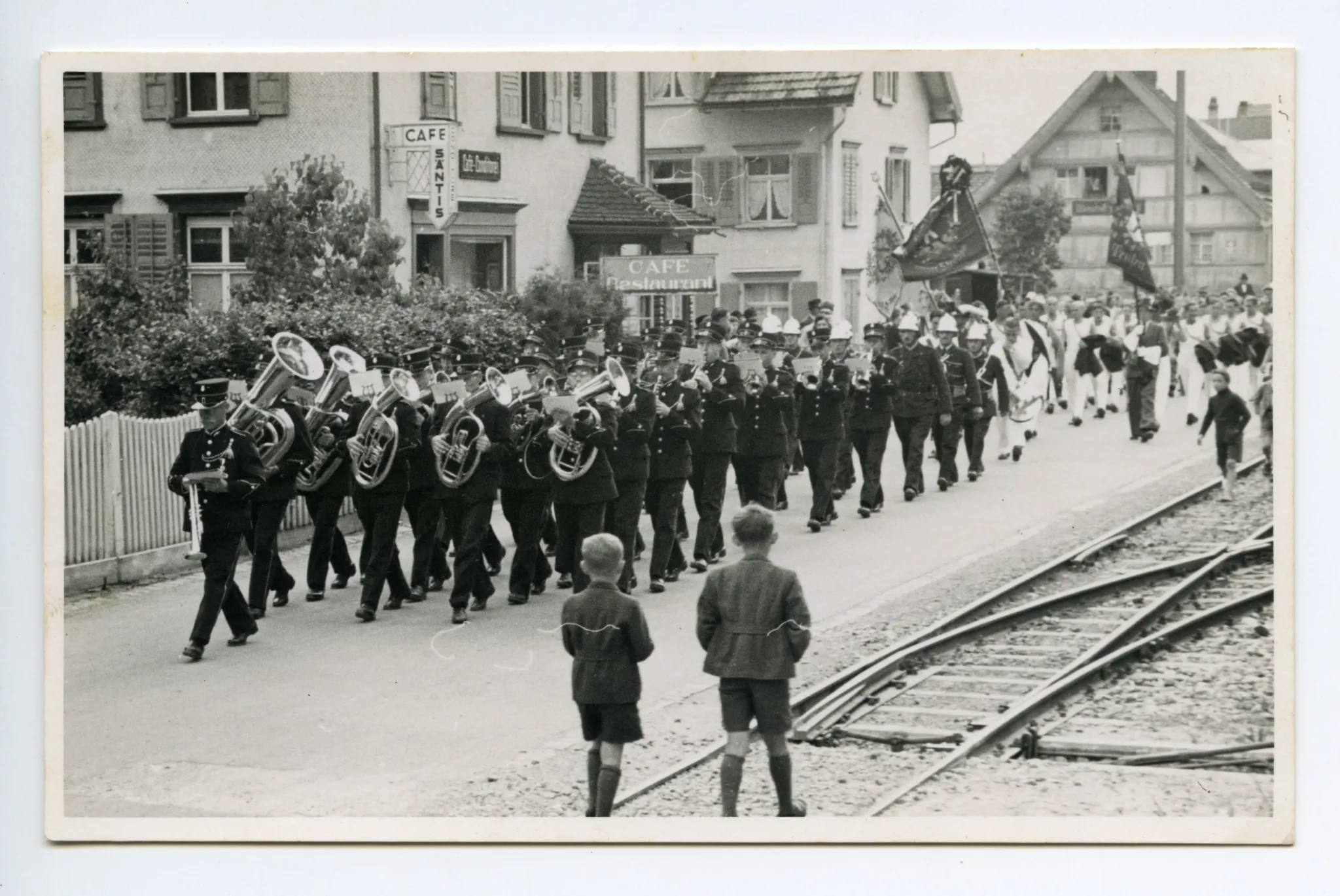 (Fahnenweihe Musikgesellschaft?), mit Bläsern, Feuerwehrmännern und Turnern?, am Café Säntis vorbei (Hauptstr. 95, Niederteufen)
