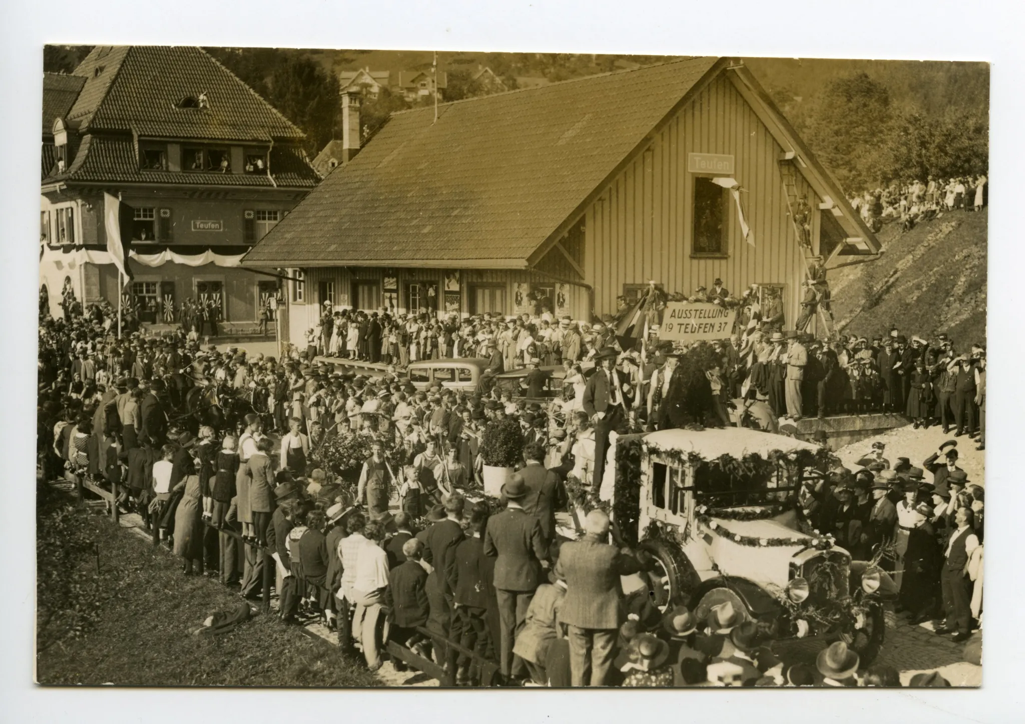vom 11. Sept. bis 4. Okt. 1937, Festumzug am Sonntag, 26. Sep. 1937, Umzug, Eröffnungswagen umgeben von vielen Zuschauern vor dem Teufner Bahnhof und Güterschuppen