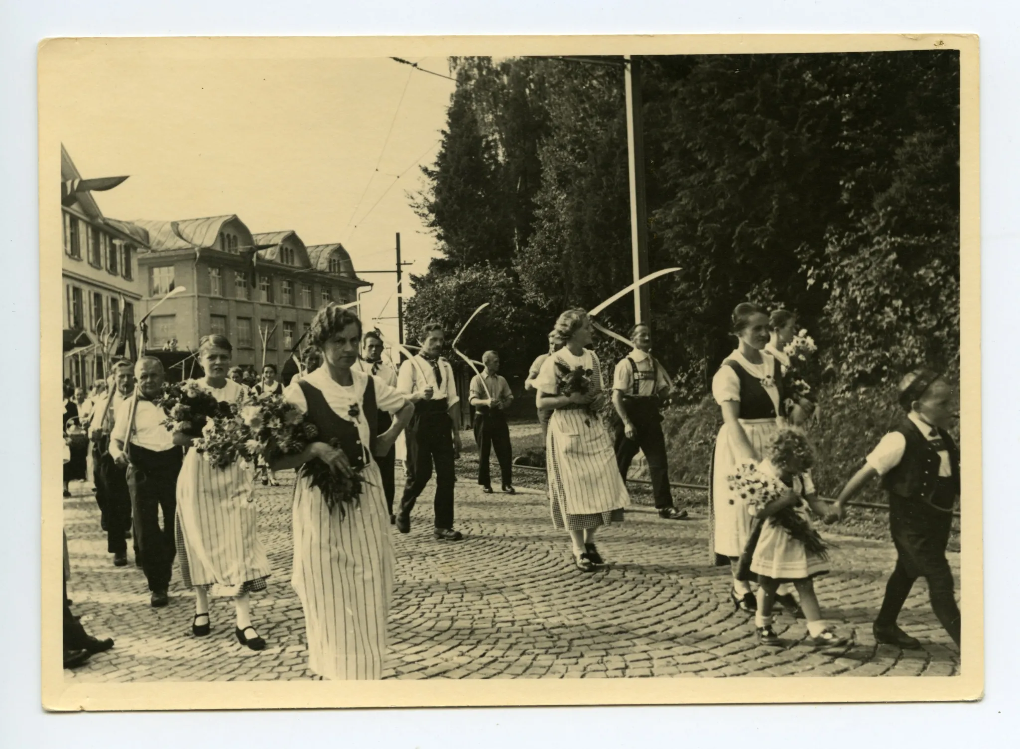 Gruppe der Bauern und Bäuerinnen laufend auf der Hauptstrasse, im Hintergrund: Gebäude Druckerei Kunz, Nahaufnahme