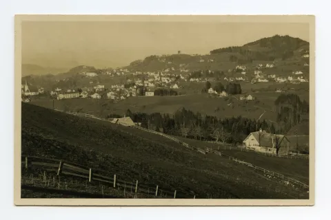 Aufnahme aus Richtung Schlatterlehn/Buechen. Beide Dorfkirchen, Zeughaus, Friedhof, Ebni, Bahnhof (halb verdeckt), Gremm/Lortanne mit Krankenhaus. Blick zu Fernblick, Schwendibüel, resp. Eggli