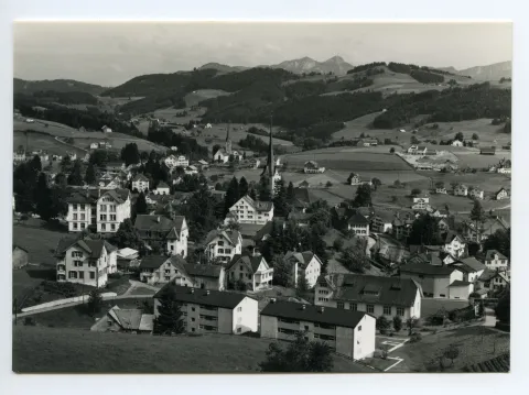 beide Dorfkirchen, SGA-Komposition zwischen Dorfplatz u. Drogerie Wetzel. Blick zum Steigbach, Kamor/Hohem Kasten. Vorne alte Turnhalle plus zwei neue MFH (zum Vergleich: Hc.17-26, Stempel 1954). Markante Baustelle/Neubau Schönenbüel (z.Vergleich ebenfalls Hc.17-26)