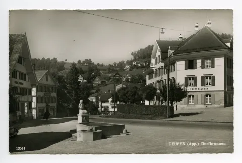 Alter Dorfbrunnen, Brückenwaage (schwach erkennbar), Alter Bahnhof („Kantonalbank“), Gasthaus „Bahnhof“, Konsum-Verein. Blick zum „Schützengarten“
