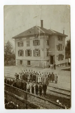 mit Schülern und Schülerinnen vor dem Schulhaus