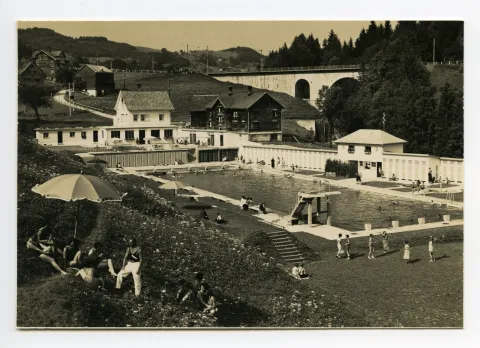 mit Badegästen und alter Bahnbrücke im Hintergrund