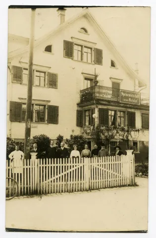 Aussenansicht mit Besitzern und Personal aufgereiht vor dem Gasthaus