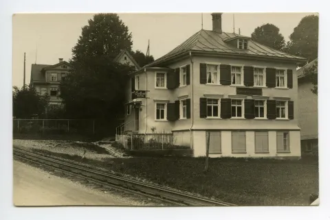 Gesamtansicht von Süden mit Bahngleis, zusätzliches Schild: „Coiffeur Ed. Früh