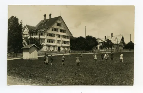Ansicht von Haupthaus und Dependace mit Kindern auf der Wiese davor