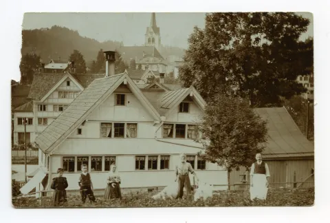 (1959 eingegangen), Rückansicht mit Personen davor, im Hintergrund evang. Kirche (hiess früher Leuen, Leuenbächli)