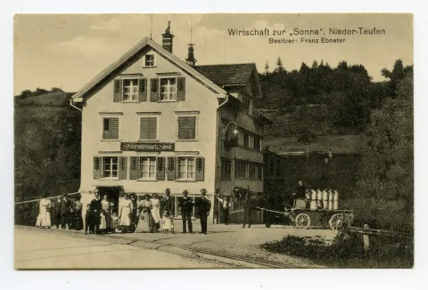 (abgebrannt 1917), Ansicht aus Süden mit Personen davor, Pferdefuhrwerk mit Tansen beladen und Bahnschienen im Vordergrund