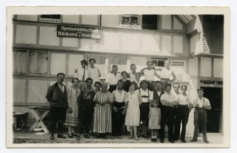 aufgereihte Personengruppe vor dem Haus