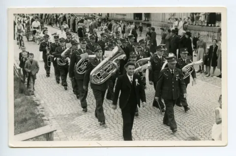 Umzug durchs Dorf auf der Strasse vor dem Güterschuppen, viele Schaulustige