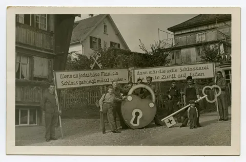 Gruppenbild der Schlosser, Vorbereitung für den Umzug mit Riesenschloss und Riesenschlüssel