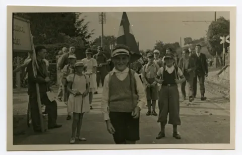 Gruppe von Kindern mit Wanderstöcken und Rücksäcken in Sportbekleidung
