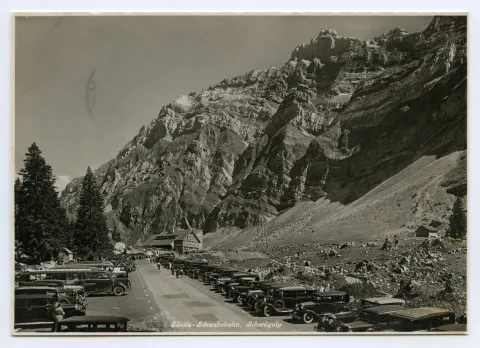 mit dem Gasthaus Schwägalp im Hintergrund und vielen parkierenden Autos rechts und links der Zufahrtstrasse